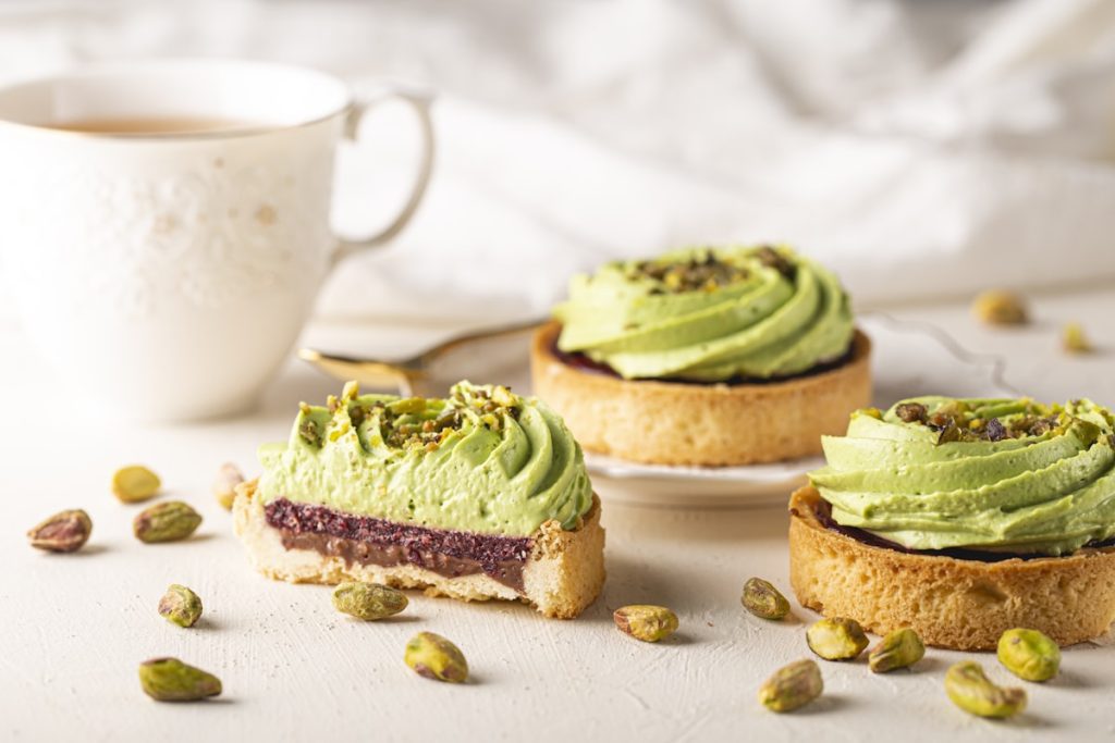 Pistachio gooey butter cake slices with cream cheese filling on a rustic surface, golden and gooey